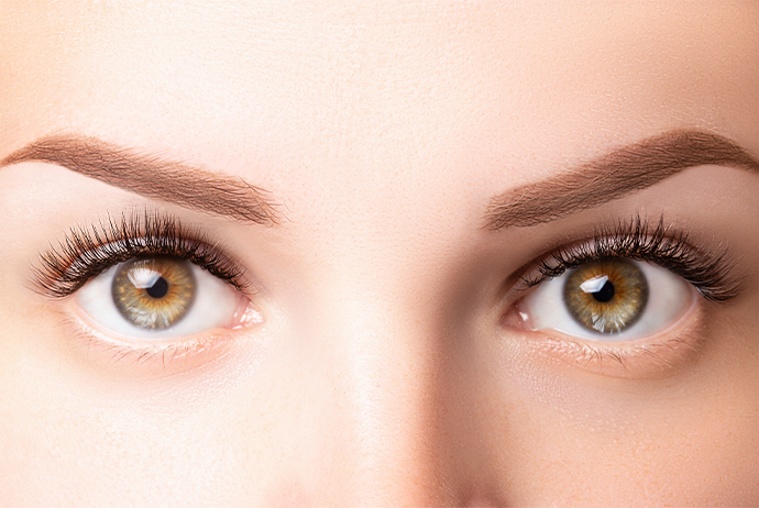 A imagem mostra, em close, os olhos de uma mulher branca, de olhos verdes e sobrancelhas castanho-claro.